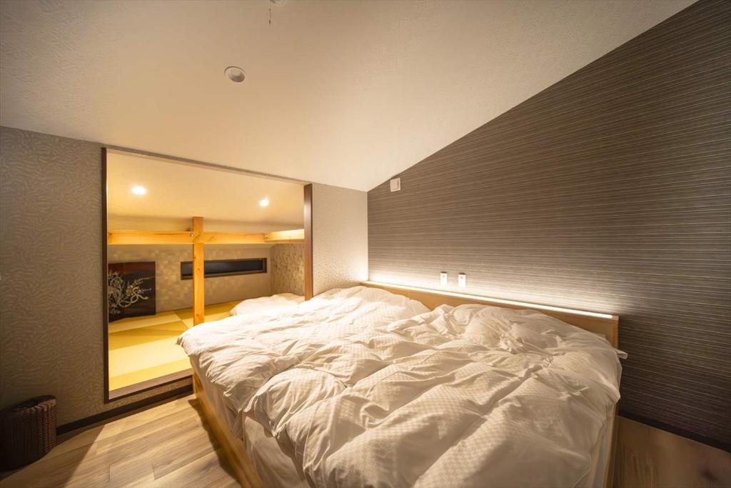 uma grande cama branca num quarto com um espelho grande em Private Villa ietona em Fujikawaguchiko