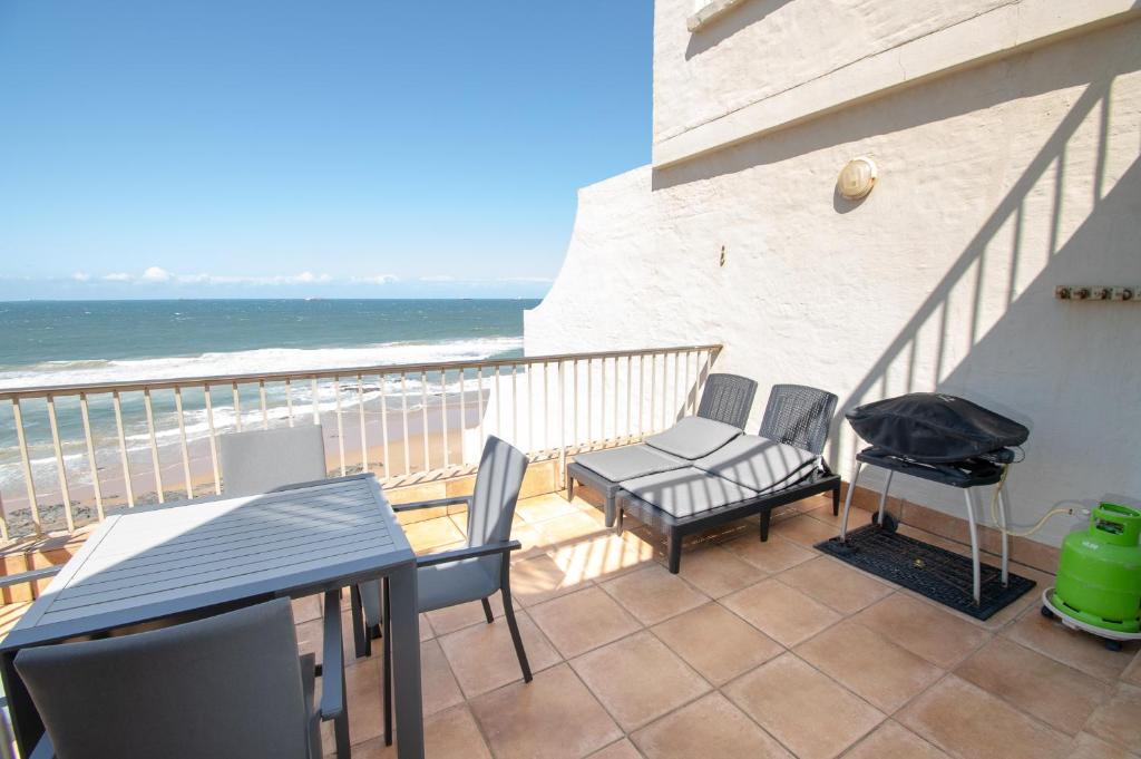 a balcony with a table and chairs and the ocean at 21 Bronze Bay Umhlanga Rocks in Durban