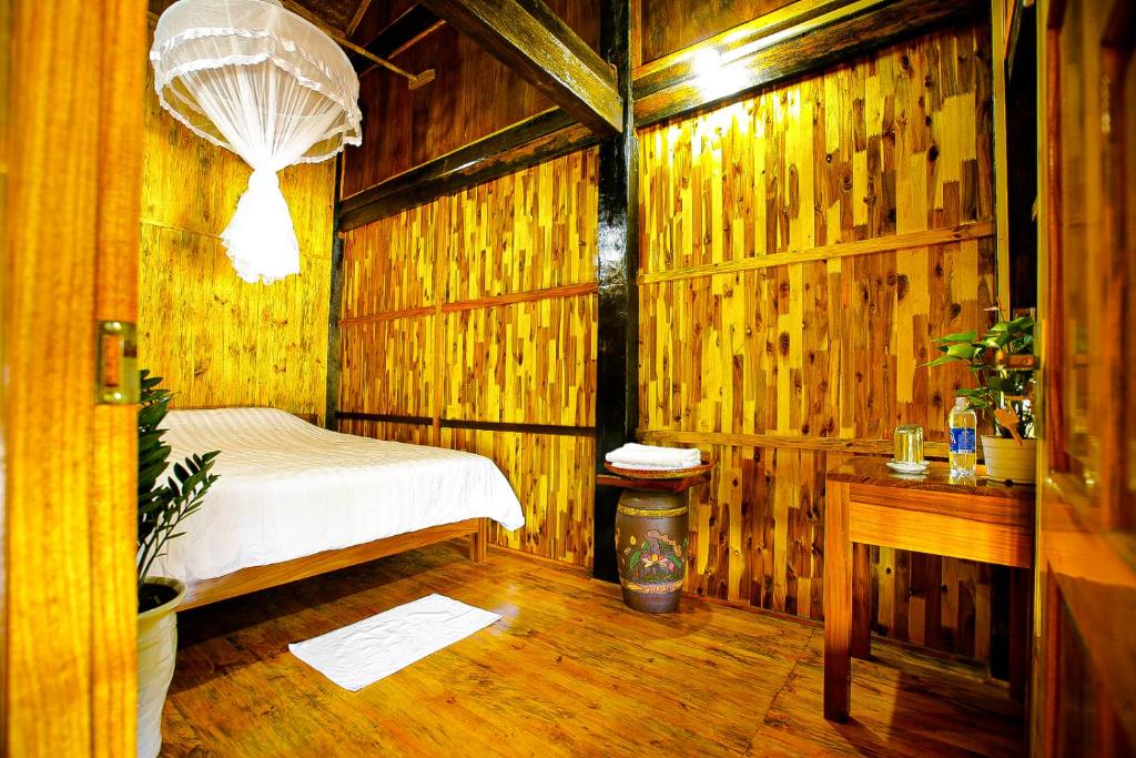 Ba Be Jungle Houses في Ba Be18: غرفة نوم بسرير في غرفة خشبية