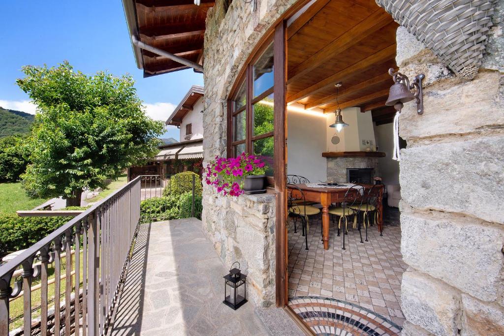 een patio met een tafel en stoelen op een balkon bij Farmhouse of Grandfather Chek in Bellagio