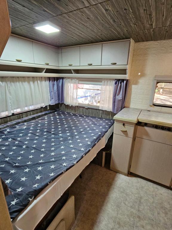 a small bed in the back of an rv at Каравана ИГЛАНД in Chernomorets