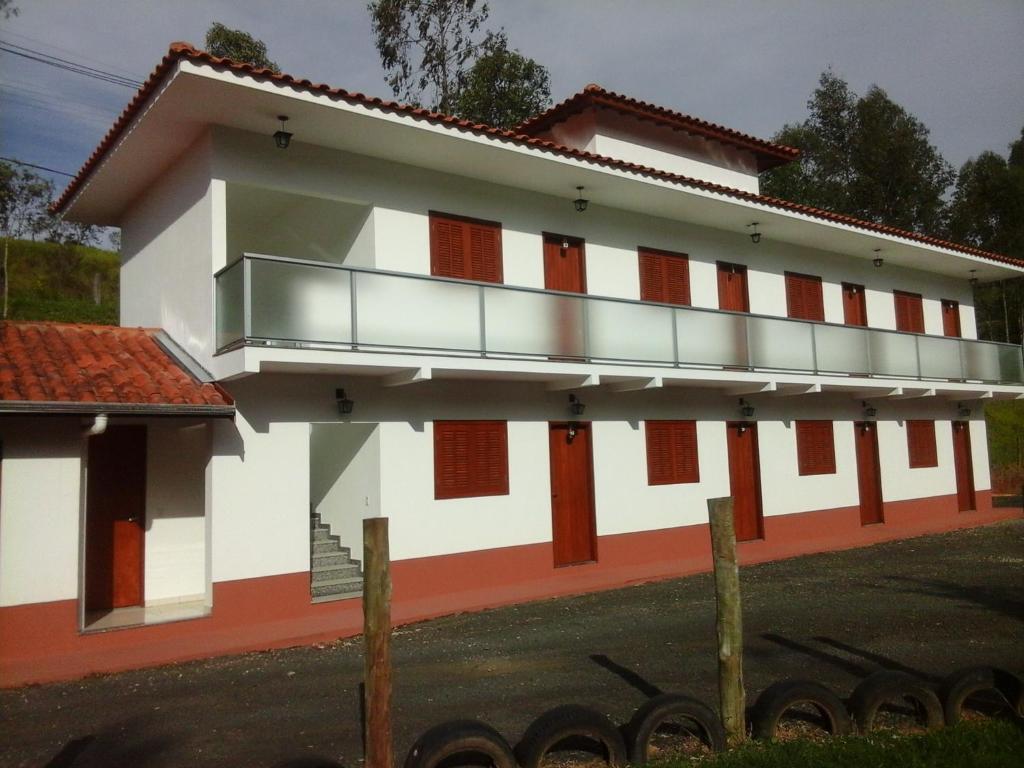 a white and orange building with a balcony at Hotel Lindoia Rural in Lindóia