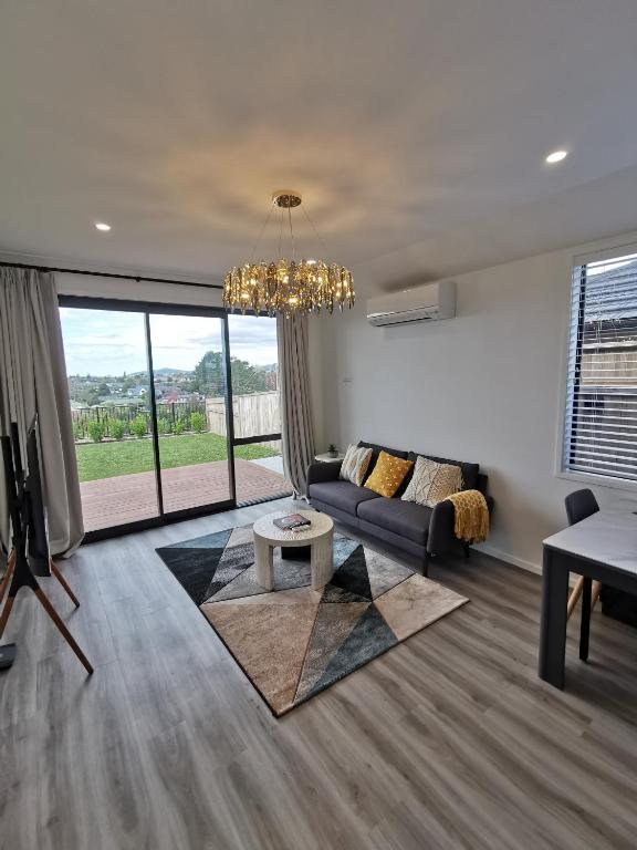 uma sala de estar com um sofá e uma mesa em Paradise Retreat em Tauranga