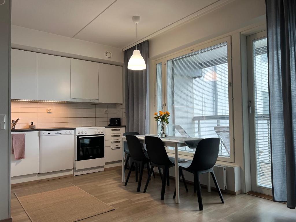 a kitchen with a dining room table and chairs at Tyylikäs 35m2 yksiö Hyrylän keskustassa in Hyrylä