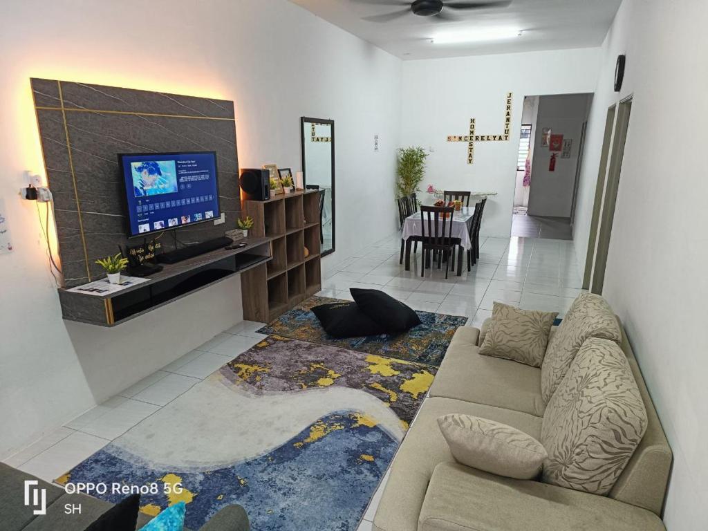 Homestay Jerantut Sincerelyat في جيرانتوت: غرفة معيشة مع أريكة وتلفزيون بشاشة مسطحة