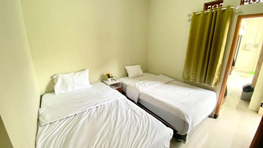 Ένα ή περισσότερα κρεβάτια σε δωμάτιο στο MADINA GUEST HOUSE Syariah near Gembira Loka Zoo Yogyakarta Mitra RedDoorz