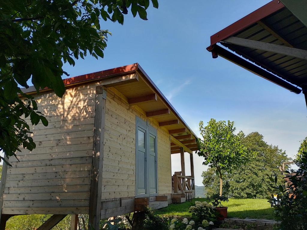 una pequeña casa con un porche en un campo en Oddih pr Toniqu en Most na Soči