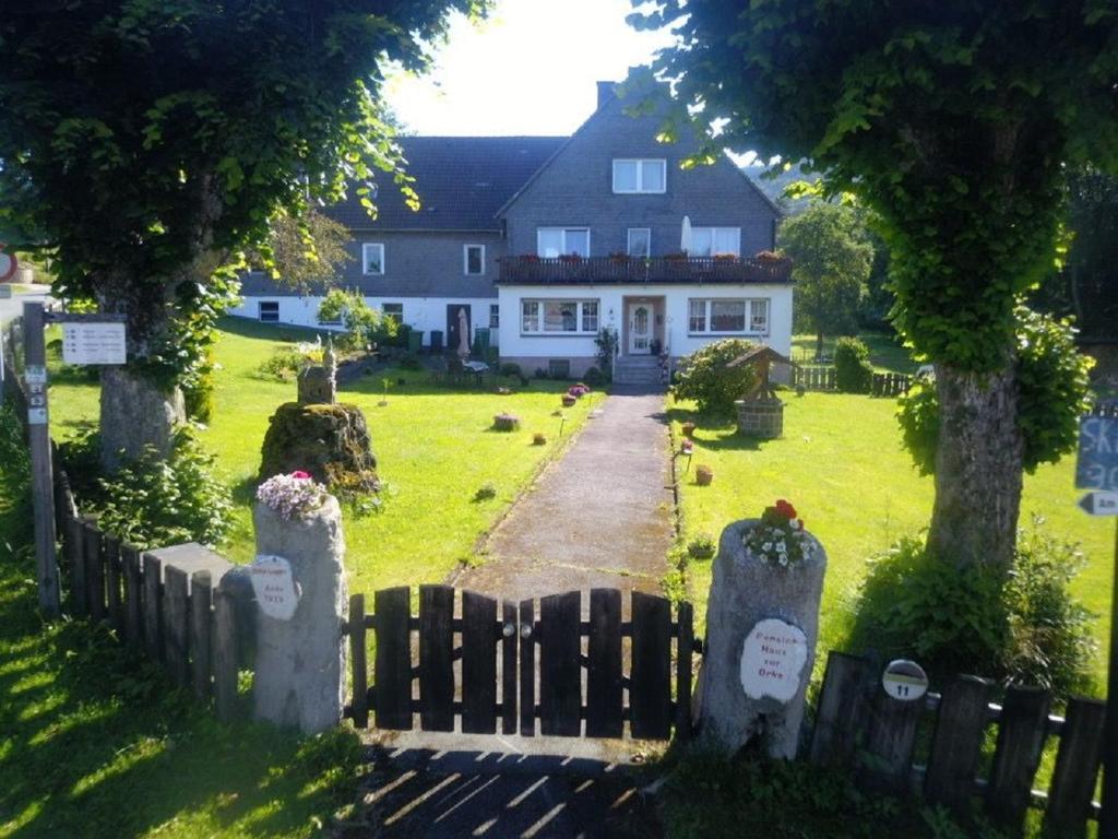 une maison avec une clôture devant une cour dans l'établissement Pension Haus zur Orke, à Winterberg
