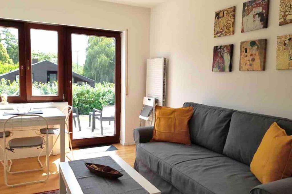 ein Wohnzimmer mit einem grauen Sofa und einem Tisch in der Unterkunft Stilvolles Apartment nahe Therme und PreZero Arena in Sinsheim