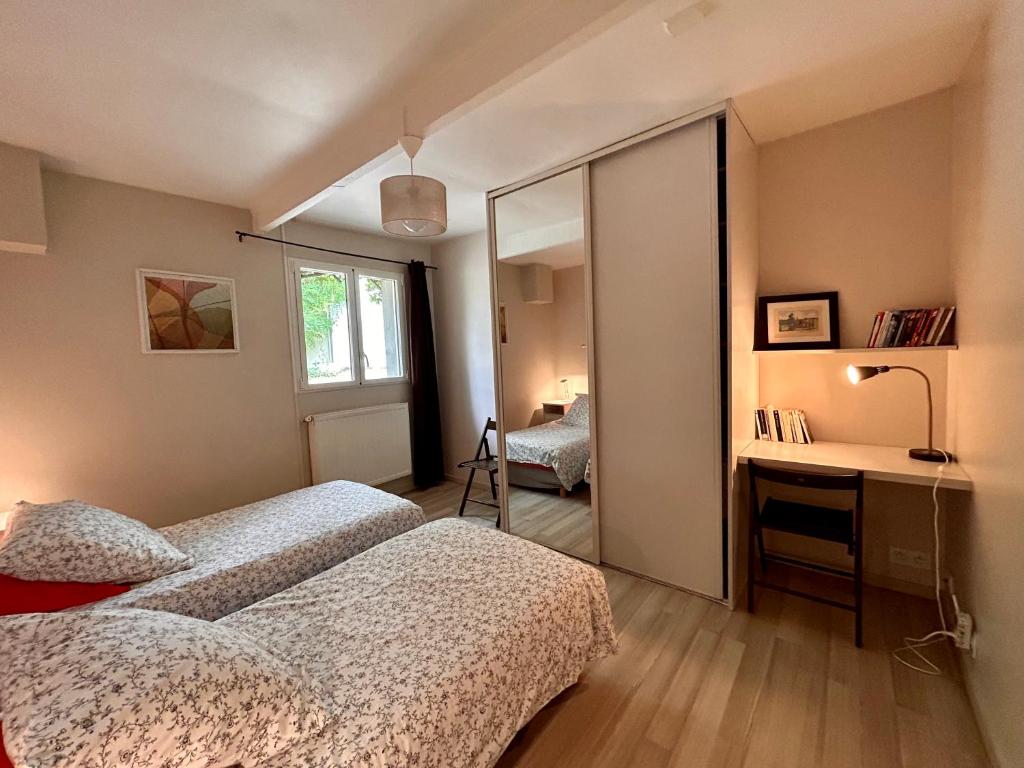 een slaapkamer met 2 bedden en een spiegel bij Séjour au vert in Vert
