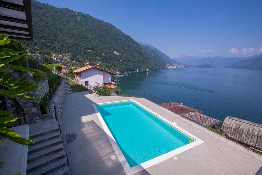 a swimming pool next to a large body of water at Residence degli Oleandri 6A in Argegno