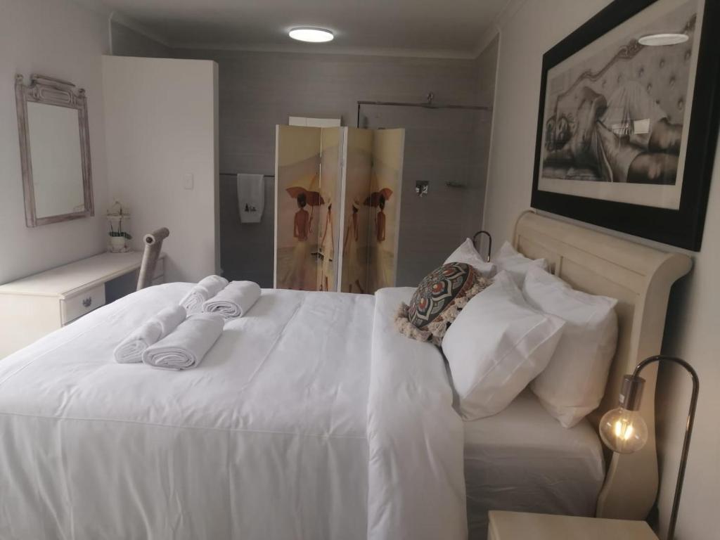 a white bed with two towels on top of it at Pet Friendly Bartholomeus Diaz beach in Mossel Bay