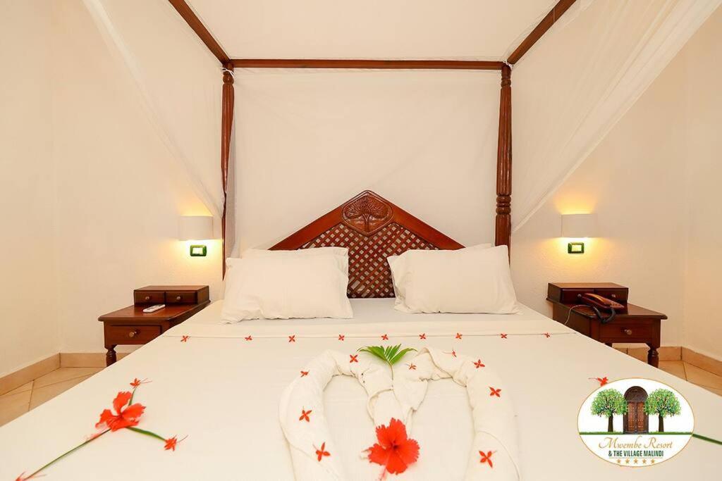 a bedroom with a bed with flowers on it at Cheerful 2-bedroom Villa with a pool at Malindi in Malindi