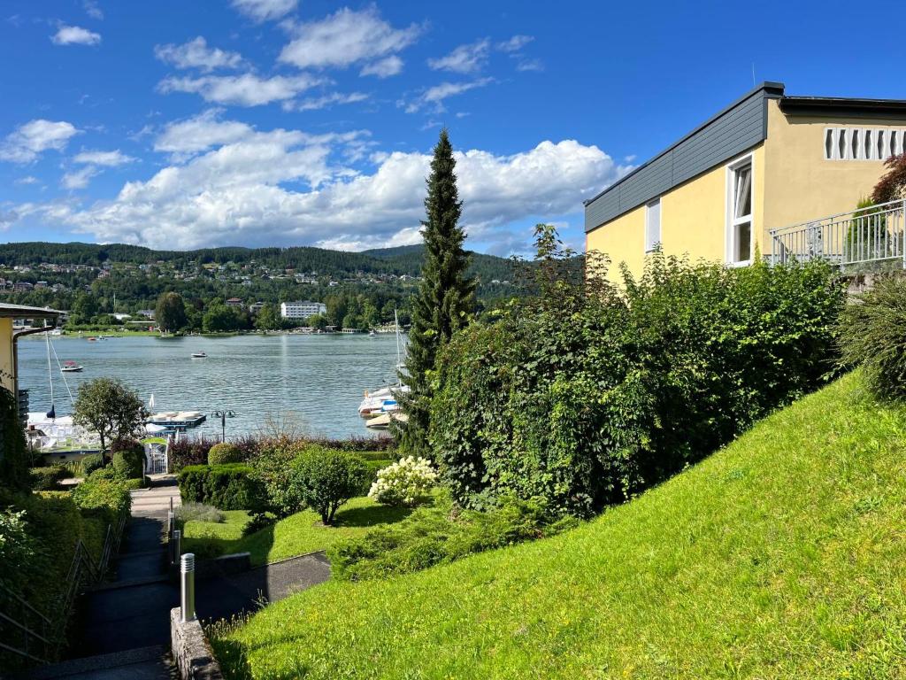 a house on a hill next to a lake at Apartment Seecorso - VEL205 by Interhome in Velden am Wörthersee