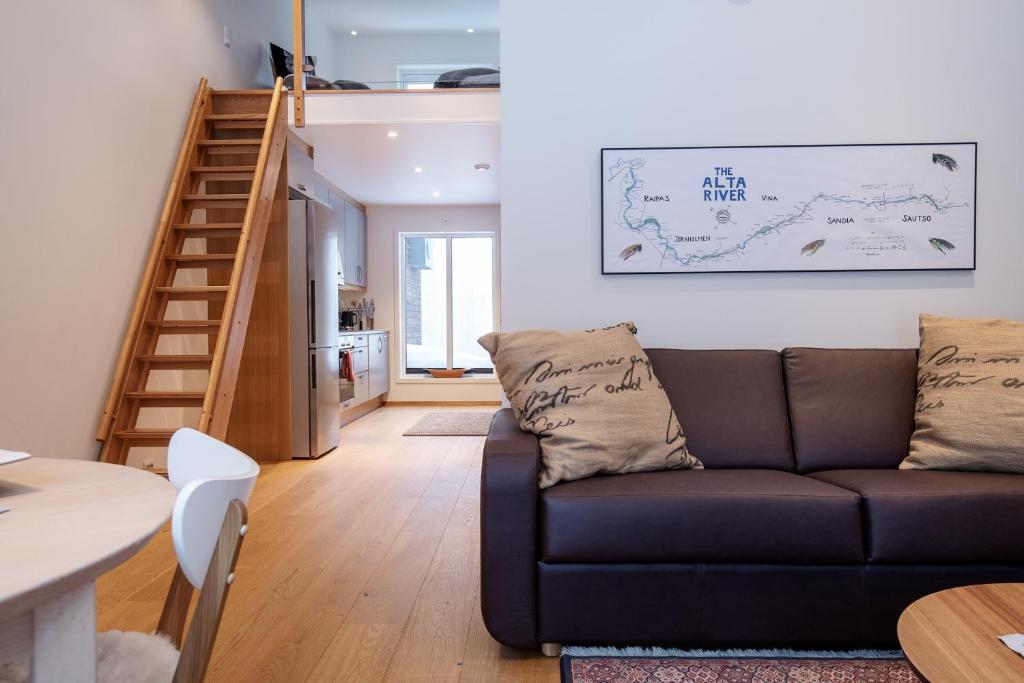 a living room with a couch and a staircase at GLØD Boutique Apartment in Alta