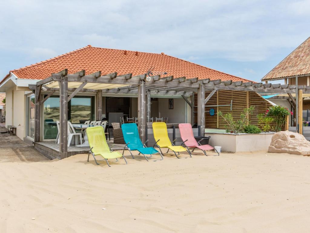a group of chairs sitting in the sand on the beach at Holiday Home Les Baïnes - VIB220 by Interhome in Vieux-Boucau-les-Bains