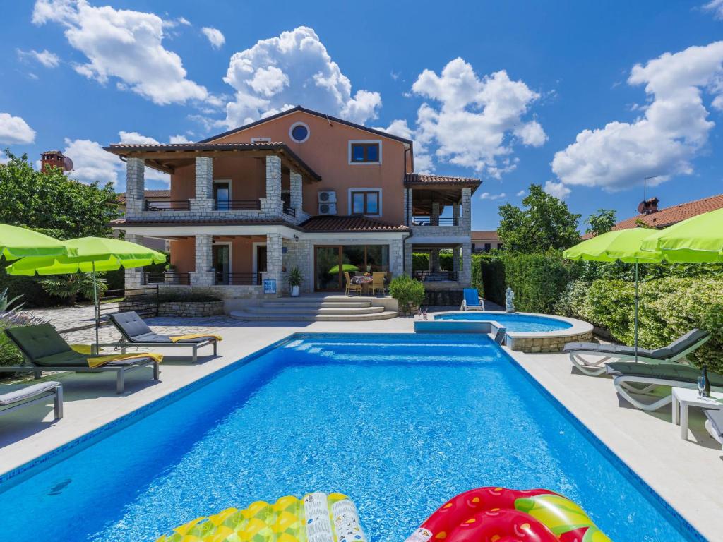 a villa with a swimming pool and a house at Holiday Home Villa Anamaria by Interhome in Plovanija