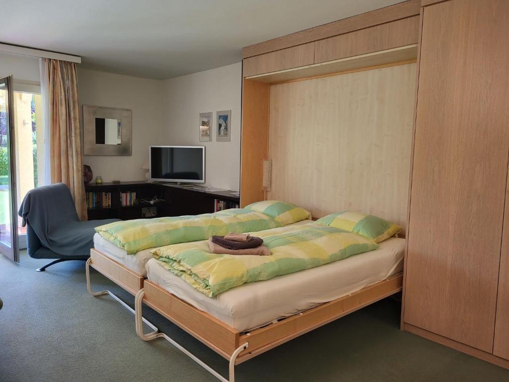 sypialnia z dużym łóżkiem i biurkiem w obiekcie Apartment Parcolago - Utoring-29 by Interhome w mieście Caslano