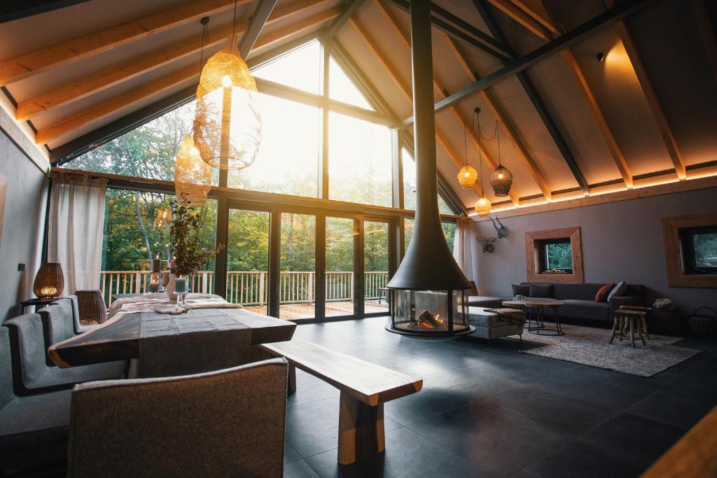 a living room with a fireplace and a large window at Chalet SALAMANDRA in Banská Štiavnica