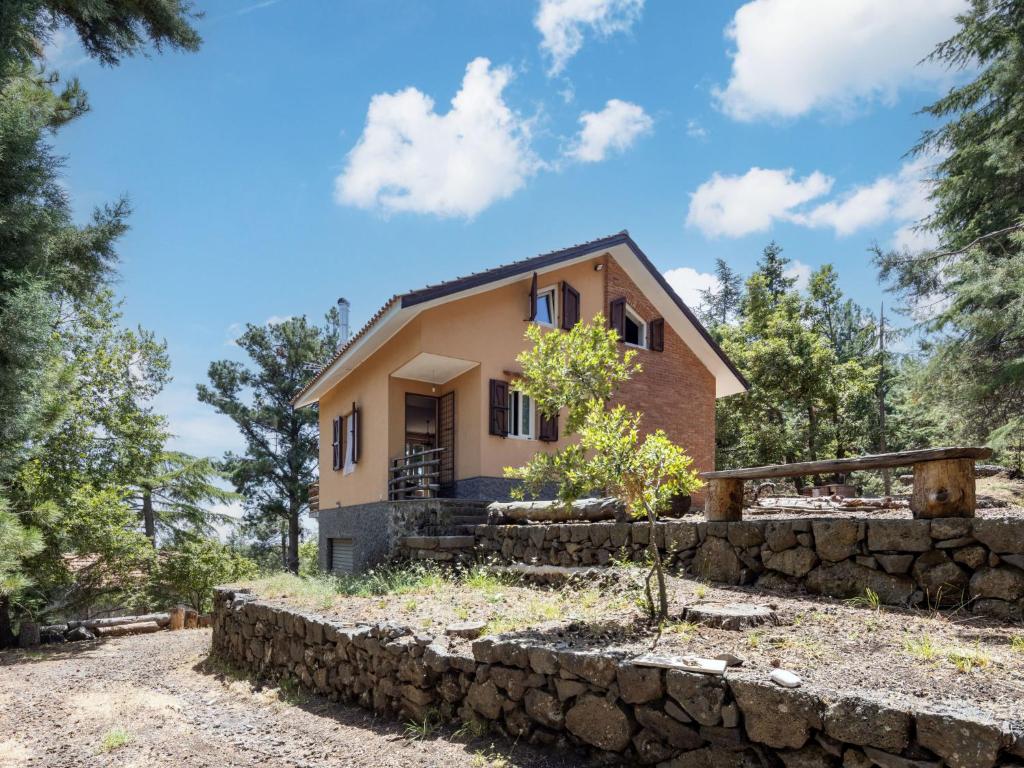 a house in the woods with a stone wall at Villa Mareneve by Interhome in Linguaglossa
