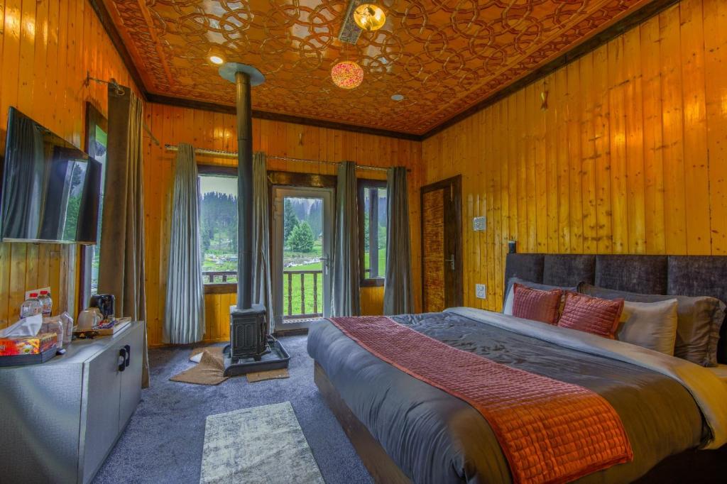 a bedroom with a bed and a fireplace in it at Gulmarg Woods By Stay Pattern in Gulmarg