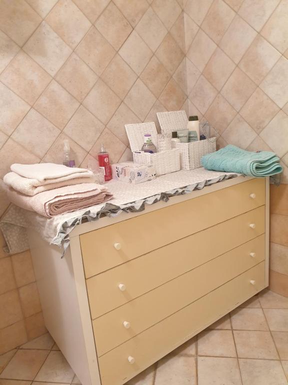 um balcão de casa de banho com toalhas e cosméticos em Intero Appartamento "ALLE MURA DEL CASTELLO Stefano e Paola Marchesini" em Gorizia