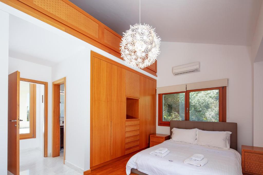 a bedroom with a bed and a chandelier at Angels Villa in Kambánion