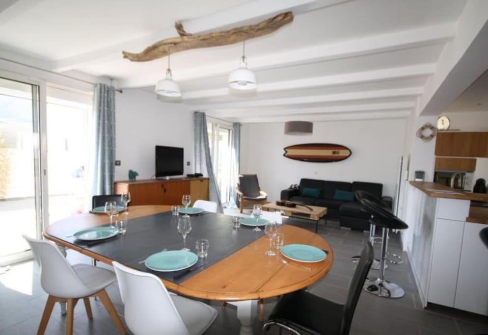 sala de estar con mesa de comedor con sillas en Belle villa climatisée de 105m² en bord de mer., en Frontignan