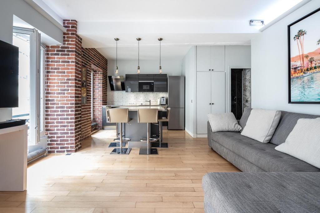 un salon avec un canapé et une cuisine dans l'établissement Stay In a prime location Paris, à Paris