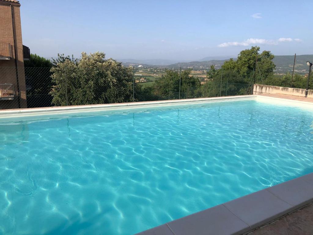 una grande piscina con acqua blu di Casetta in Collina a Castello delle Forme
