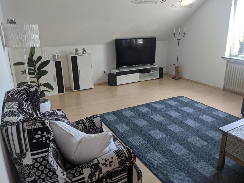 a living room with two chairs and a flat screen tv at FeWo Wiesenallee OG in Geeste