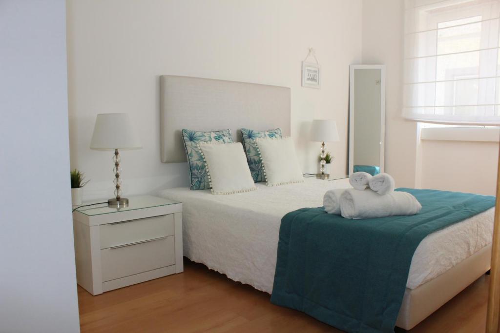 a bedroom with a bed with two teddy bears on it at Casa Carvalho Laranjo in Nazaré