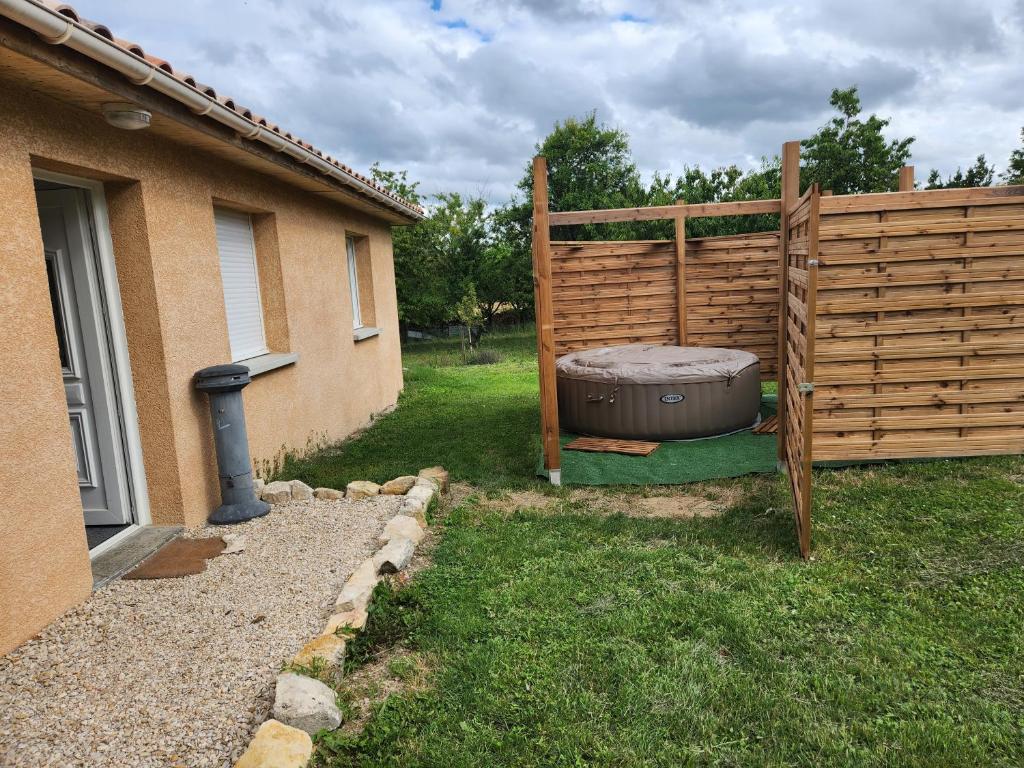 einen Hinterhof mit einem Whirlpool neben einem Zaun in der Unterkunft Gîte de Pierre et Christine in Vanault-les-Dames
