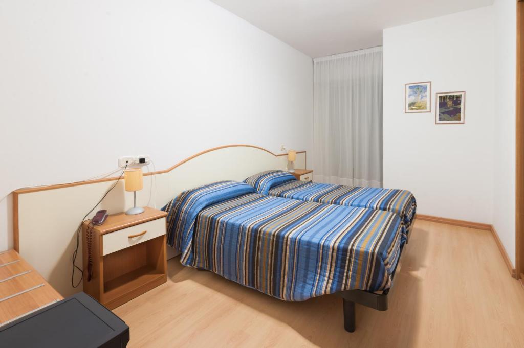 A bed or beds in a room at Hotel Garni Losanna