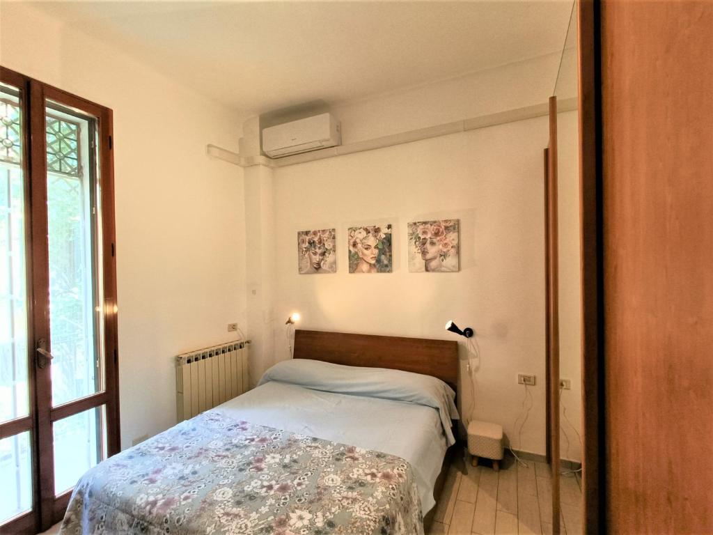 Schlafzimmer mit einem Bett und einem Fenster in der Unterkunft Palagi Suite in Bologna