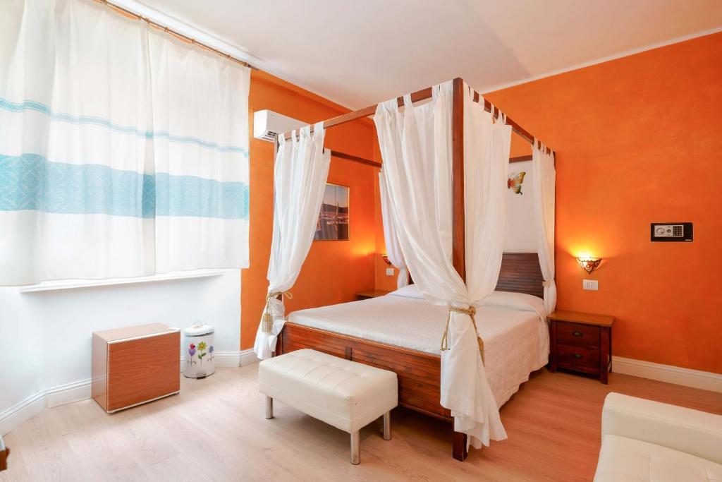 a bedroom with a canopy bed and orange walls at Villabeachcity Guesthouse in Cagliari