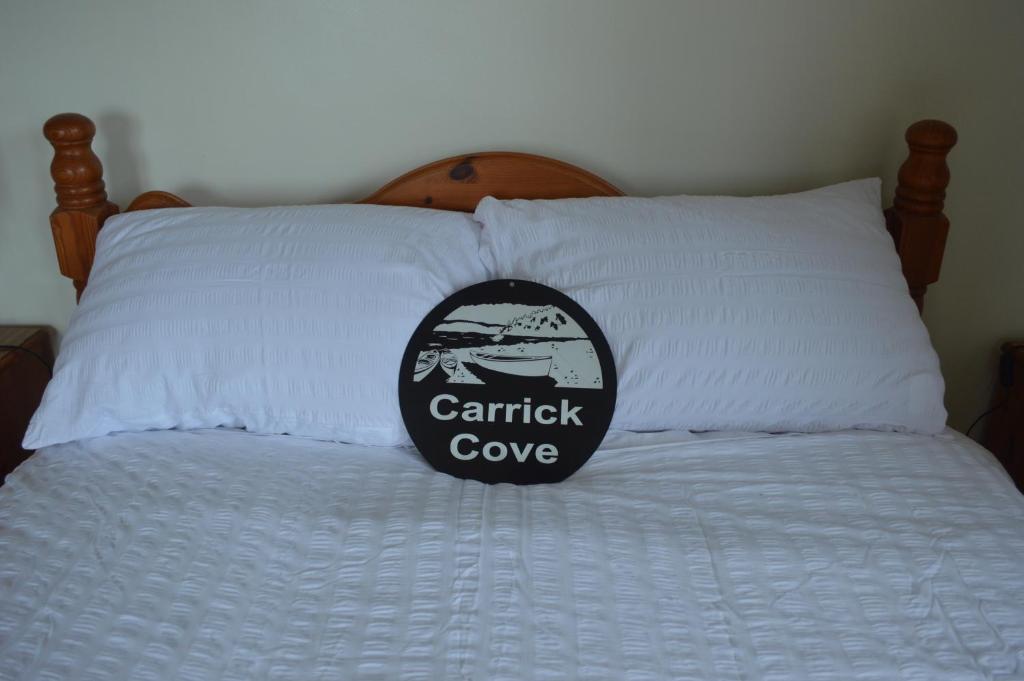 Una almohada con un parche en ella sentada en una cama en Carrick Cove Deluxe Room with private decking, en Annalong