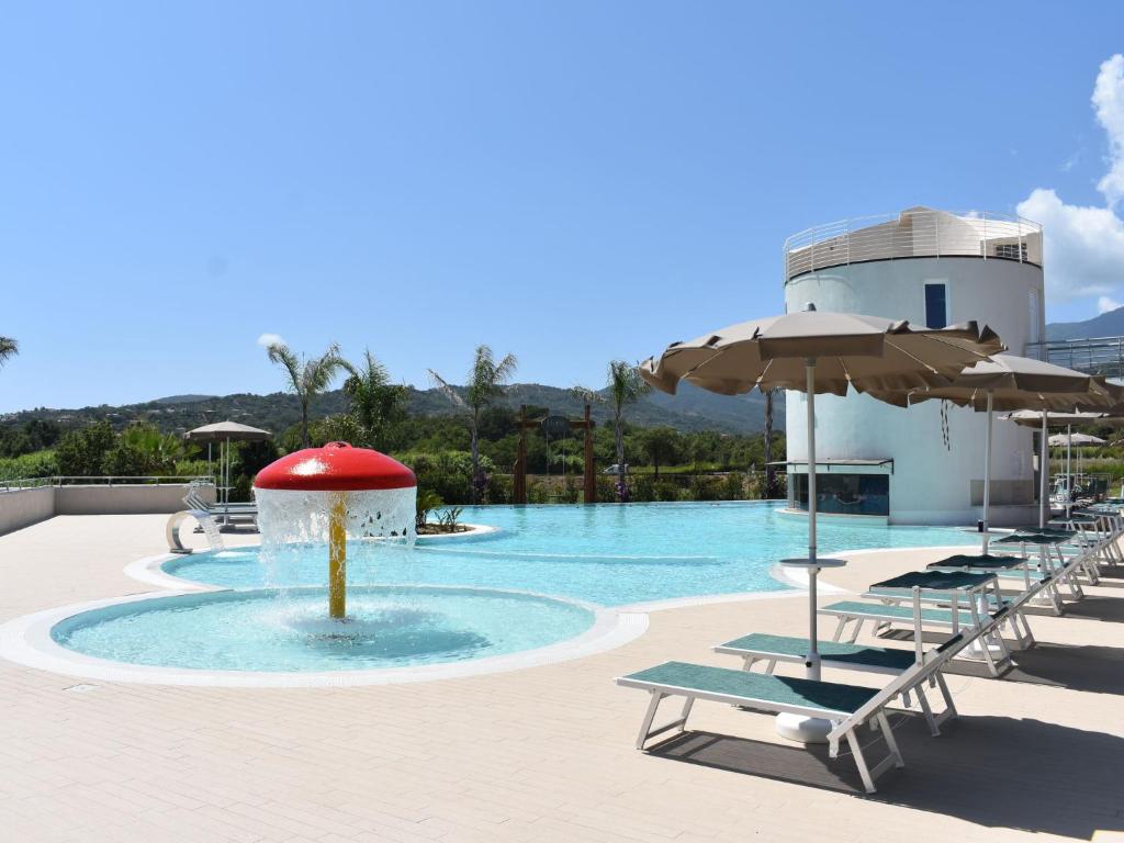 einen Pool mit Stühlen und Sonnenschirmen sowie einen Pool in der Unterkunft Apartment Hyele Accomodation Experience-4 by Interhome in Marina di Casalvelino