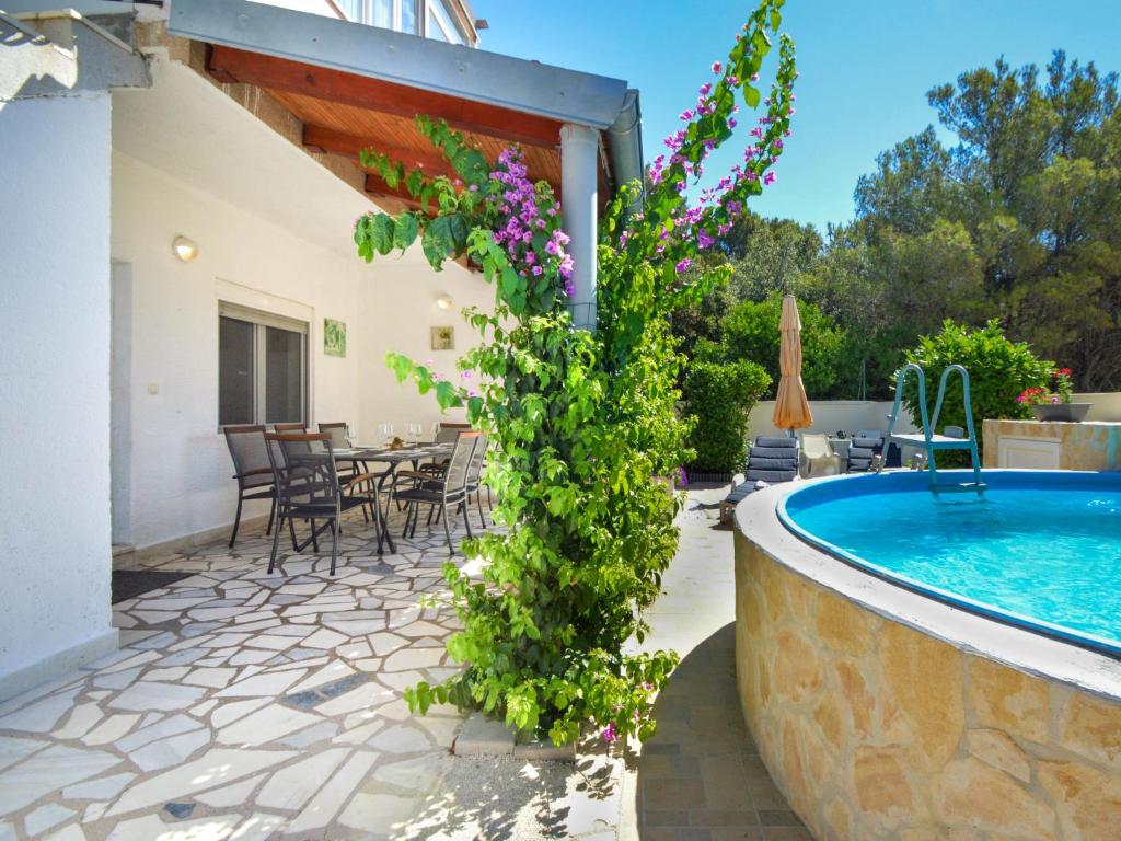a patio with a pool and a table and chairs at Holiday Home Gabi by Interhome in Brodarica