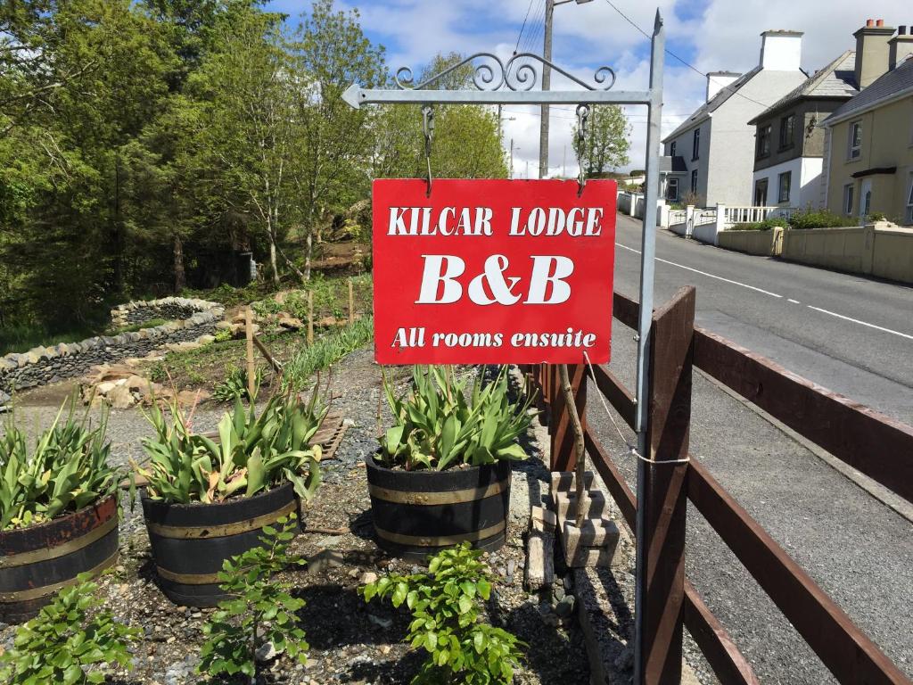 a sign for a kitchen lodge bbq on the side of a road at Kilcar Lodge in Kilcar