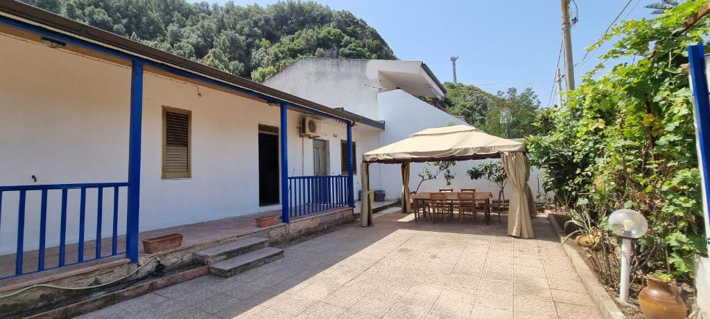 un patio con mesa y sombrilla en Villa Rosetta - Casa Vacanze, en Palmi