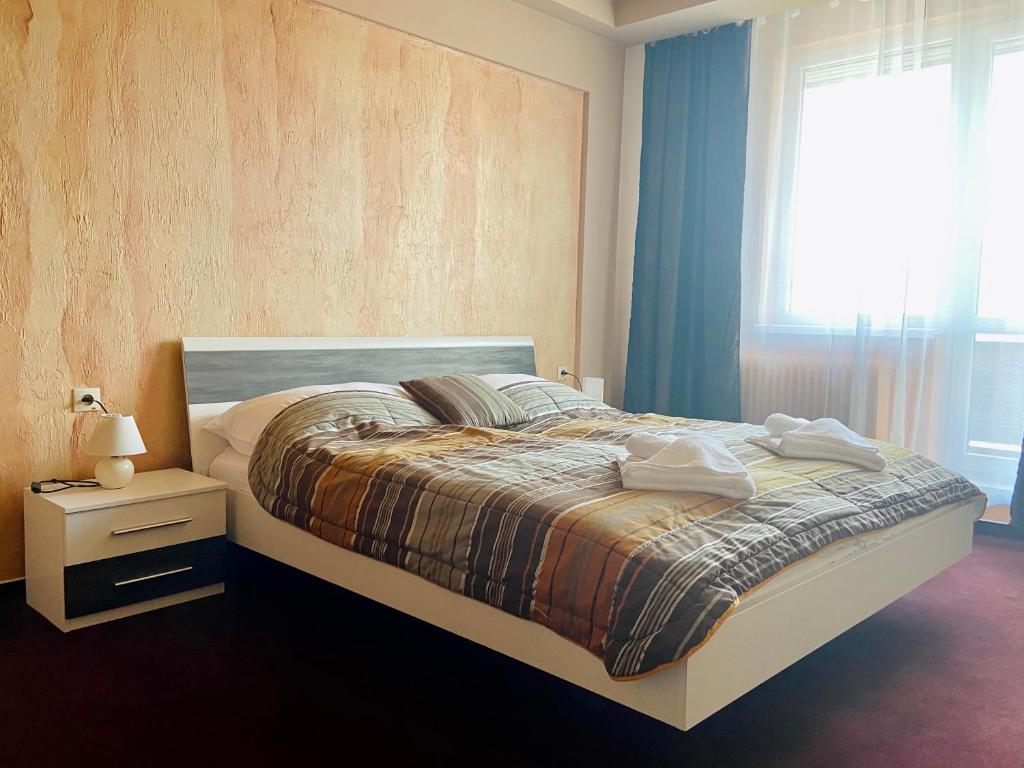 a bedroom with a large bed with a window at Hotel Ďumbier in Brezno