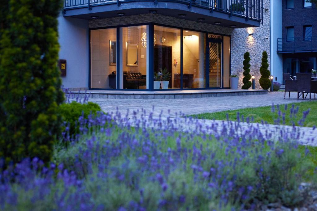 a house with a garden with purple flowers in front of it at Alcest Niechorze in Niechorze