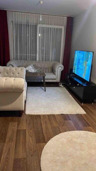 a living room with a couch and a tv at Lux site icerisinde 1+1 in Umraniye