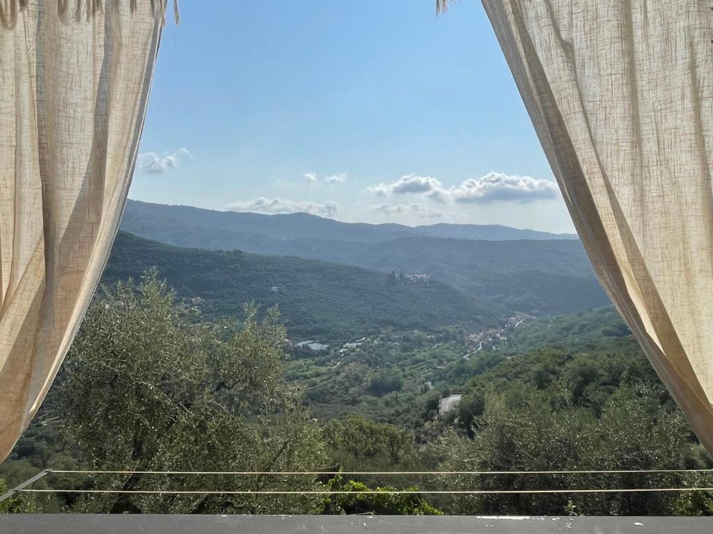 a view of the mountains from a window with curtains at Holiday Home Casa Norvegia by Interhome in Valloria