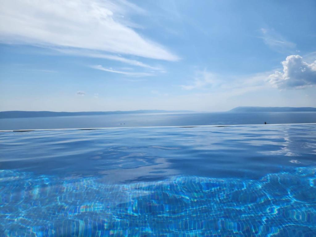 un gran cuerpo de agua con un cielo azul y nubes en Villa Lilly, en Podgora