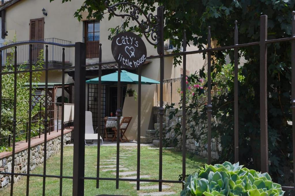 ein Tor mit einem Schild vor einem Haus in der Unterkunft Caty's little house in Cavriglia