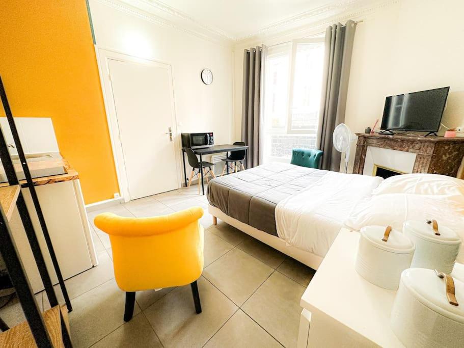um quarto de hotel com uma cama e uma cadeira amarela em Société Key-s/Meaux/Suite2-Rhapsody em Meaux