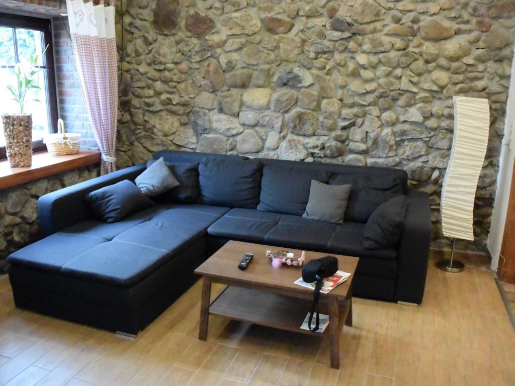 niebieską kanapę w salonie z kamienną ścianą w obiekcie NEU! Moderne FeWo Nähe Plauer See 