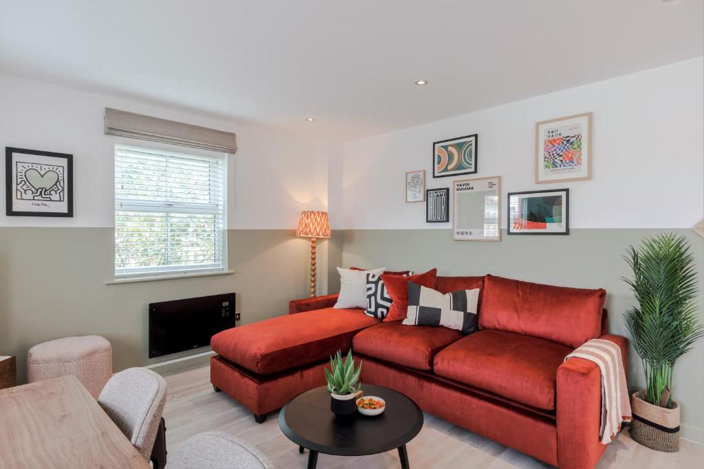 倫敦的住宿－Southwark Serviced Apartments I Your Apartment，客厅配有红色沙发和电视